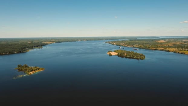 Rural landscape, sky, lake, river, forest, field. Aerial view lake with islands against the blue sky
