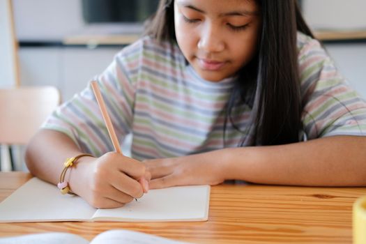 asian girl student studying writing notes doing homework in library. learning education at school