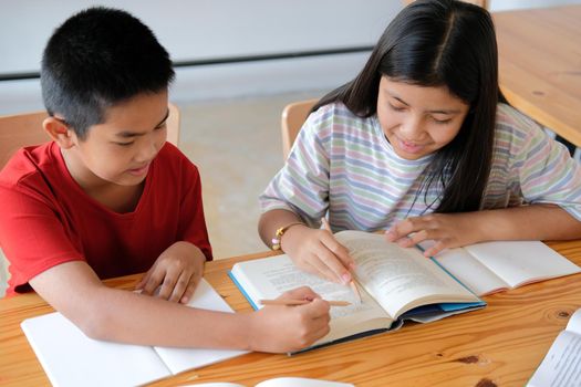 asian boy girl student studying doing homework in library. learning education at school