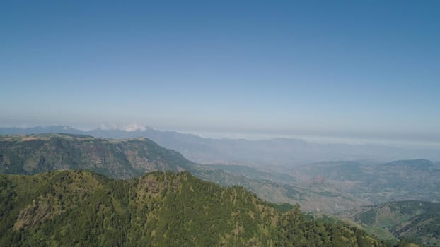 Aerial view of mountains covered forest, trees in clouds. Cordillera region. Luzon, Philippines. Slopes of mountains with evergreen vegetation. Mountainous tropical landscape.