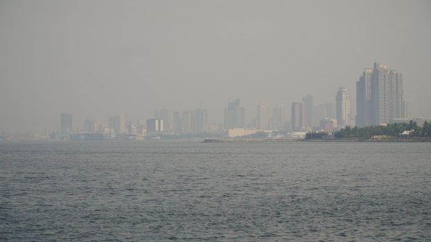 Panorama Manila city, skyscrapers and buildings. Seascape coastal city of Manila. Modern city by sea. Makati district. Travel concept.