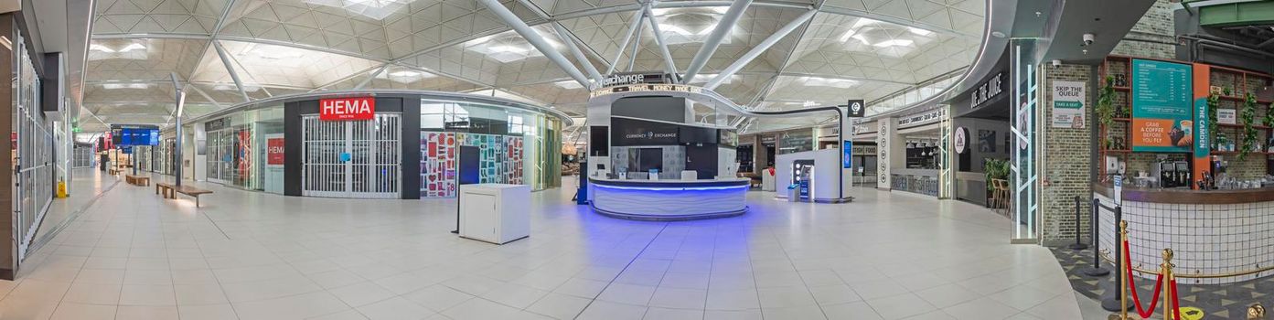 LONDON STANSTED, ENGLAND - FEBRUARY 6TH 2021:  Empty airport departure hall with closed shops on February 6th 2021. International flights were badly affected by the corona virus pandemic travel ban