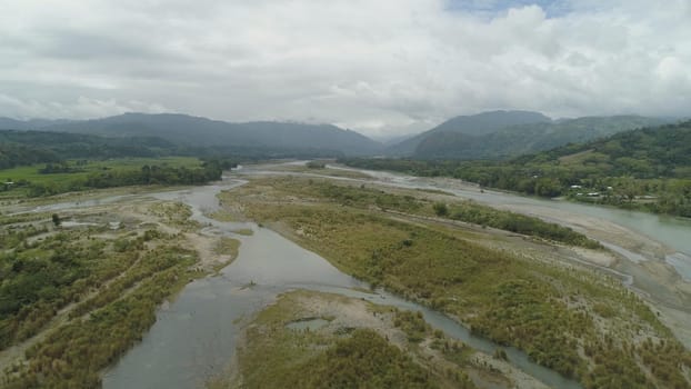 Mountain valley with river, farmland in the Philippines, Luzon. Aerial view of mountains covered forest, tree. Cordillera region.