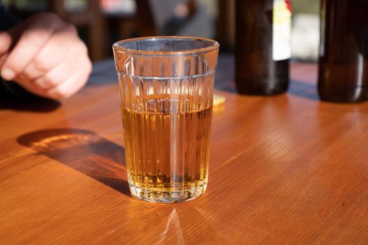 A glass of lemonade on the wooden surface of the table.