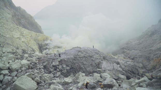 Extraction of sulfur in the crater of a volcano. Sulfur gas, smoke. Kawah Ijen, crater with acidic crater lake where sulfur is mined. Ijen volcano complex is a group of stratovolcanoes in the Banyuwangi Regency of East Java, Indonesia.