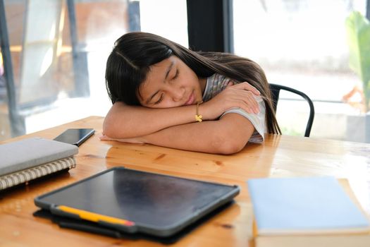 tired exhausted asian girl student sleeping after studying hard exam in library