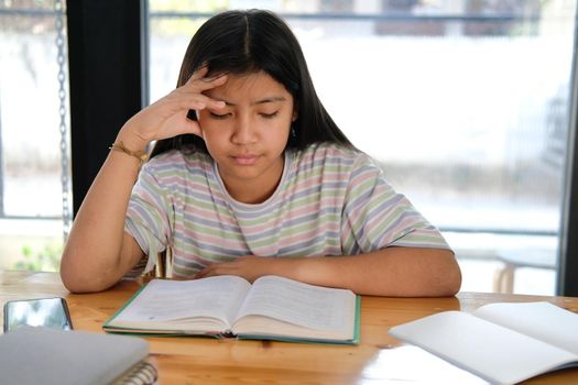 asian girl student studying hard feeling stressed tired exhausted bored. children education