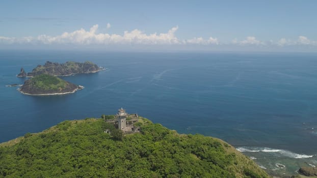 Aerial view of lighthouse in Palau island. Lighthouse in cape Engano against blue sky and rocky islands, province of Cagayan, Philippines.