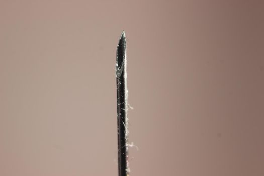 Close-up of vaccine drop on syringe needle. Water drop falling from the syringe needle