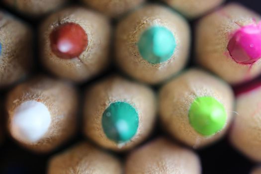 Close-up view of bright colored multicolor pencils on black background