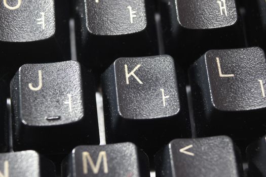 Closeup of laptop computer keyboard black keys with white letters and numbers. Black keys with white characters.