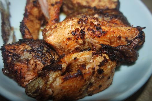 Spicy and crunchy barbecue of fried fish fillet on a white background. Homemade grilled trout fish steaks for health nourishments.