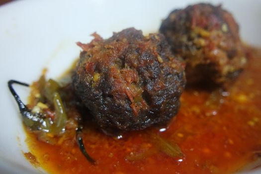 Closeup view with selective focus of meatball dish.Top view of meat balls or meat kofta curry in masala gravy in a ceramic plate.