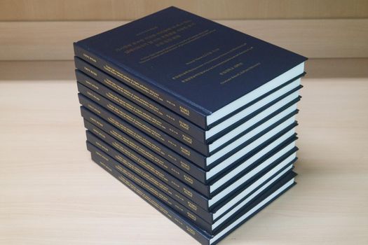 Stack of blue books placed on table. Thesis books with golden words on blue hardcover