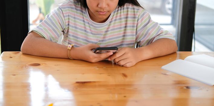 asian girl student using social media online app on smart mobile phone in library