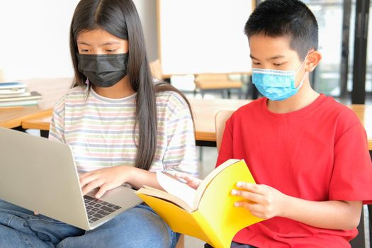 asian boy girl student wearing face mask studying learning lesson online. remote meeting distance education at home