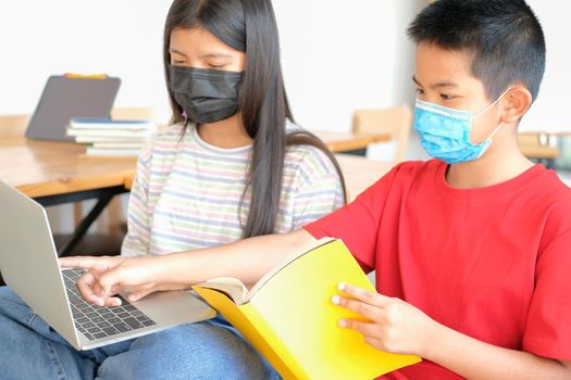 asian boy girl student wearing face mask studying learning lesson online. remote meeting distance education at home