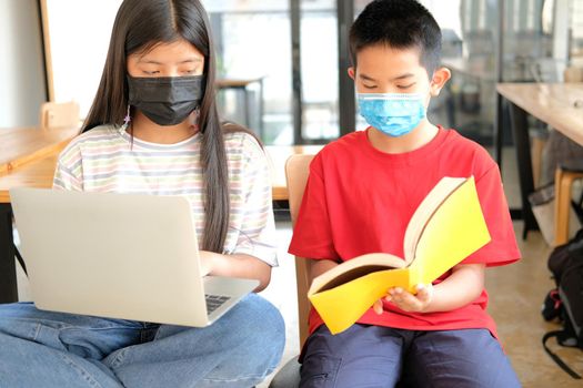 asian boy girl student wearing face mask studying learning lesson online. remote meeting distance education at home