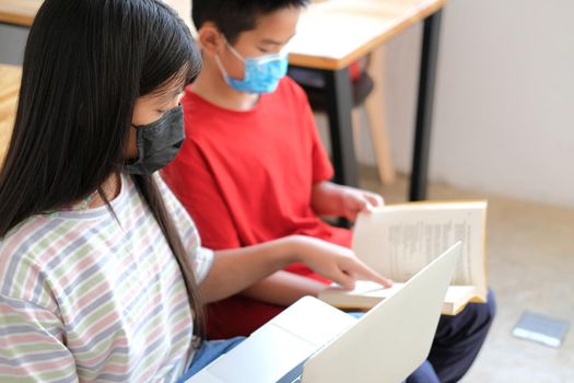 asian boy girl student wearing face mask studying learning lesson online. remote meeting distance education at home