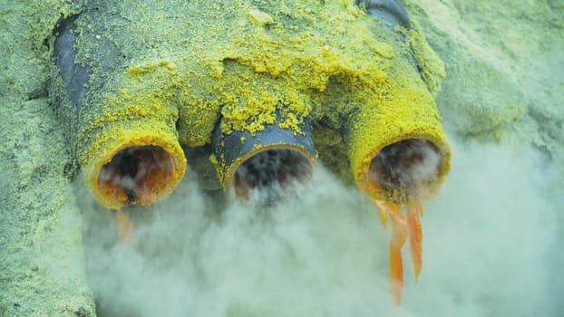 Extraction of sulfur in the crater of a volcano. Sulfur gas, smoke. Kawah Ijen, crater with acidic crater lake where sulfur is mined. Ijen volcano complex is a group of stratovolcanoes in the Banyuwangi Regency of East Java, Indonesia.
