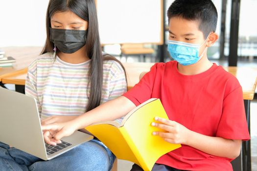 asian boy girl student wearing face mask studying learning lesson online. remote meeting distance education at home