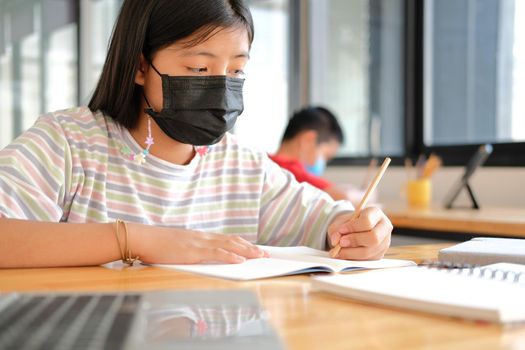 asian boy girl student wearing face mask studying learning lesson online. remote meeting distance education at home
