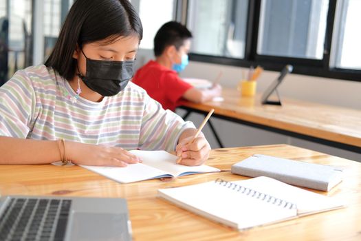 asian boy girl student wearing face mask studying learning lesson online. remote meeting distance education at home