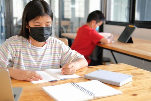 asian boy girl student wearing face mask studying learning lesson online. remote meeting distance education at home