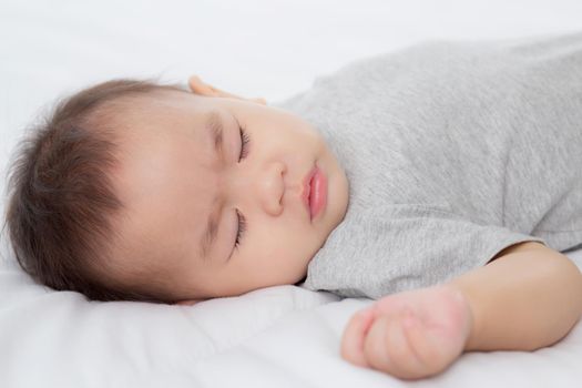 Portrait of asian little baby girl sleeping on bed in the bedroom at home, newborn napping with cozy and relax, infant innocence in bedtime, happy toddler cute, growth of child and emotion, indoors.