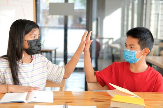 asian girl boy student friends wearing face mask giving high five at school