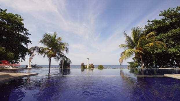 Luxury hotel,resort near at sea with pool among the palm trees. Luxurious open air swimming pool at resort. Swimming pool with turquoise water in hotel. Travel concept.