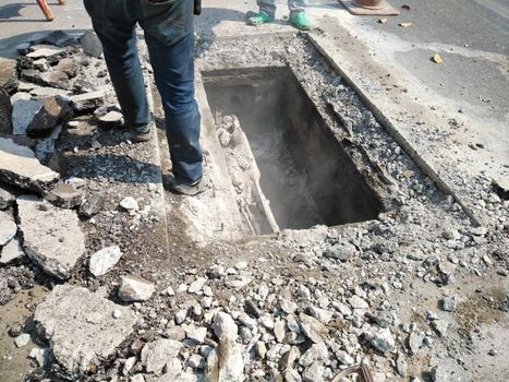 Chiang Mai, Thailand - January 27, 2021: workers digging sewer for fixing repairing underground utility service cable on Sripoom road in Chiang Mai, Thailand on January 27, 2021.