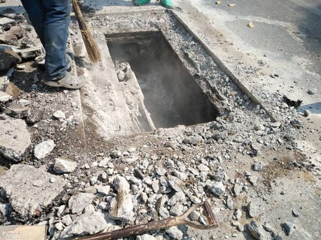 Chiang Mai, Thailand - January 27, 2021: workers digging sewer for fixing repairing underground utility service cable on Sripoom road in Chiang Mai, Thailand on January 27, 2021.