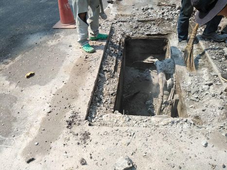 Chiang Mai, Thailand - January 27, 2021: workers digging sewer for fixing repairing underground utility service cable on Sripoom road in Chiang Mai, Thailand on January 27, 2021.