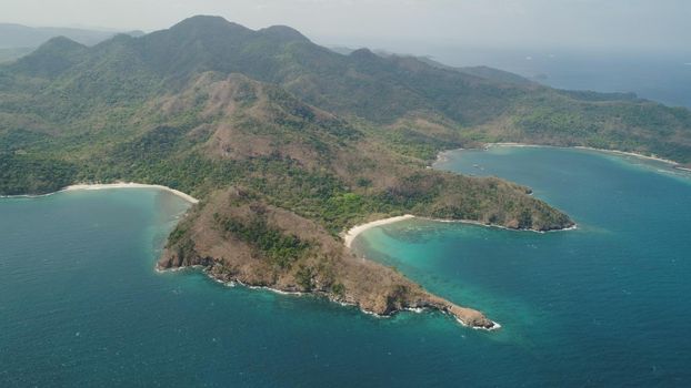 Aerial view of seashore with beach, lagoons and coral reefs. Philippines, Luzon. Coast ocean with tropical beach, turquoise water. Tropical landscape in Asia.