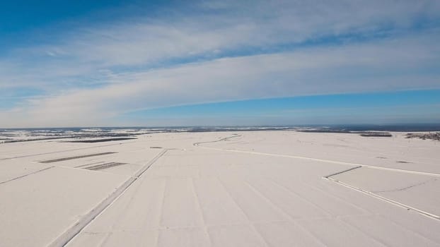 The field covered with snow in a winter season. Aerial view: Winter landscape countryside, field. Feld covered with frost snow.