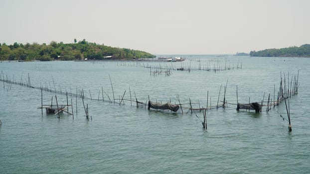 Fish farm with cages for fish and shrimp in the Philippines, Luzon. Fish ponds for bangus, milkfish. Fish cage for tilapia, milkfish farming aquaculture or pisciculture practices.
