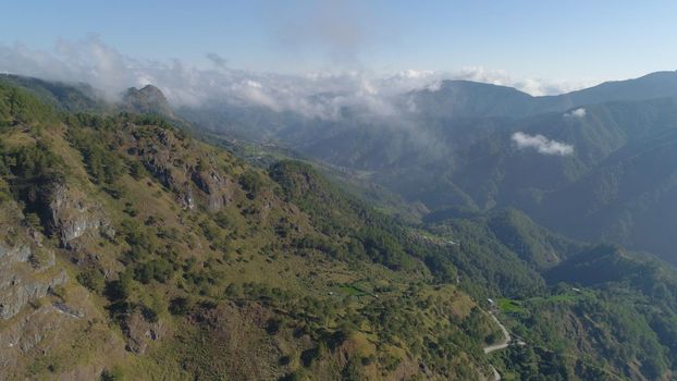 Aerial view of mountains covered forest, trees in clouds. Cordillera region. Luzon, Philippines. Slopes of mountains with evergreen vegetation. Mountainous tropical landscape.