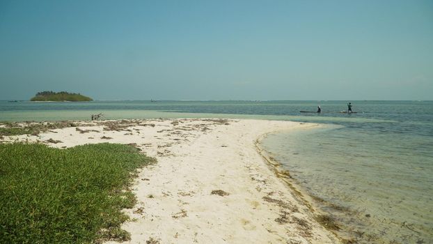 Tropical island with white sandy beach in blue lagoon. Tondol white sand beach with turquoise water. Seascape, ocean and beautiful beach. Philippines, Anda, Pangasinan. Travel concept.