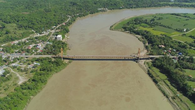 Aerial view of modern bridge with cars over tropical river in mountain province Philippines,Luzon.