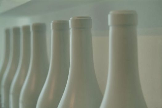 wine bottles close up view of the necks white painted perspective view selective focus