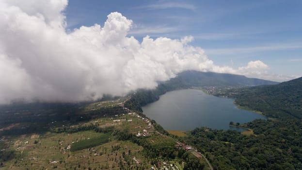 Aerial view of Lake Tamblingan, a caldera lake at Bali. Beautiful lake with turquoise water in the mountains of the island of Bali. Landscape, lake among mountains, sky, clouds.