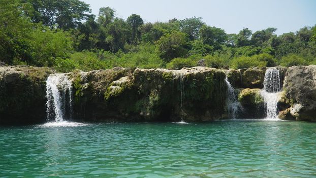 Waterfall in green rainforest. Bolinao waterfall in the mountain jungle. Philippines, Luzon. Travel concept.