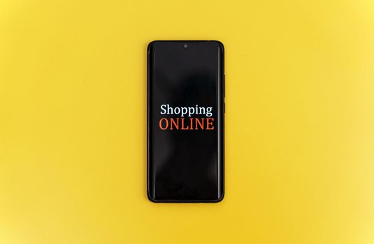 Smartphone on yellow background. Online shopping concept.