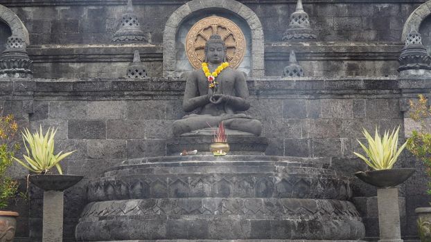 Statue of the Buddhist God Buddha in the Buddhist temple Brahma Vihara Arama with statues of the gods on Bali island, Indonesia. Bali Architecture, Ancient design. Travel concept.