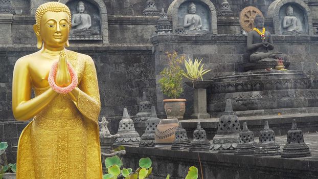 Statue of the Buddhist God Buddha in the Buddhist temple Brahma Vihara Arama with statues of the gods on Bali island, Indonesia. Bali Architecture, Ancient design. Travel concept.