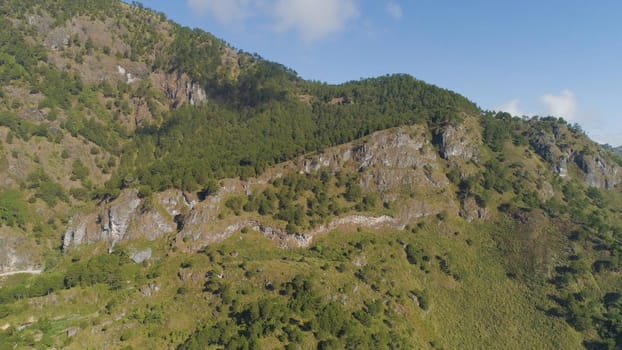 Aerial view of mountains covered forest, trees in clouds. Cordillera region. Luzon, Philippines. Slopes of mountains with evergreen vegetation. Mountainous tropical landscape.