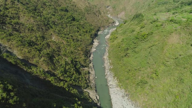 Aerial view of mountain river in the cordillera gorge, mountains covered forest, trees. Cordillera region. Luzon, Philippines. Mountain landscape.