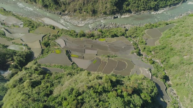 Aerial view of mountain valley in the cordillera, river, rice terraces, farmland in the Philippines, Luzon. Aerial view of mountains covered forest, tree. Cordillera region.
