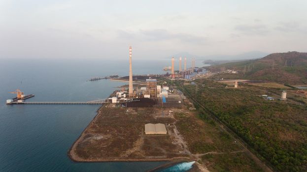 Aerial view Power station on the sea coast, Jawa island. Larger Industrial power plant in Indonesia. Power Plant cables and wires.